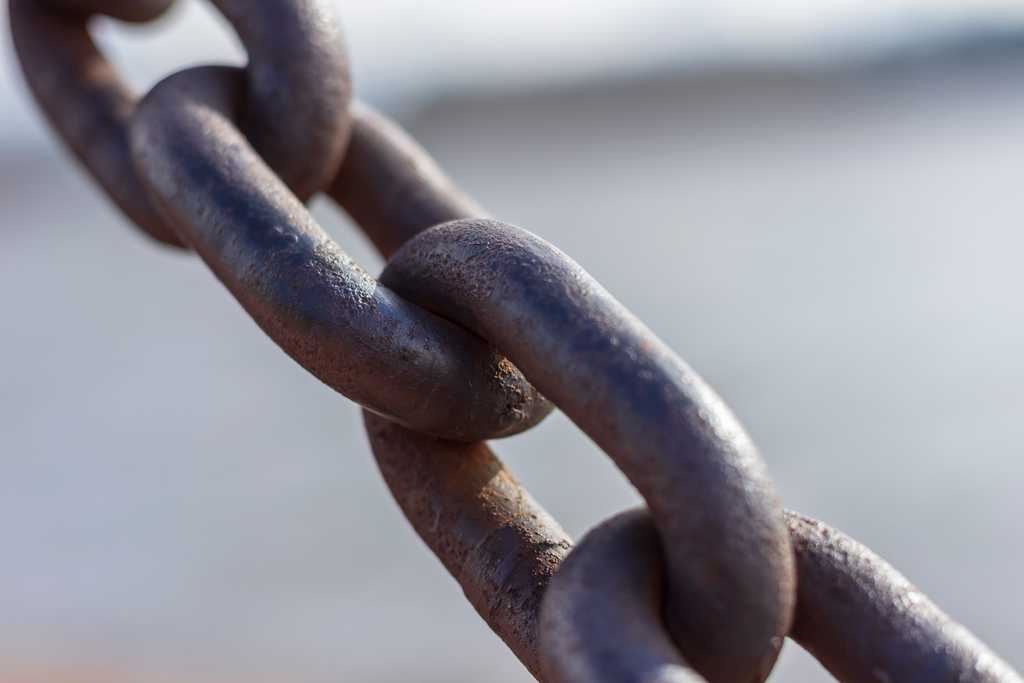Several links of a taut, heavy iron chain